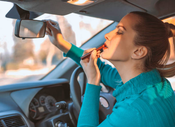 woman applying lipstick in car mirror quick everyday makeup routine on the go